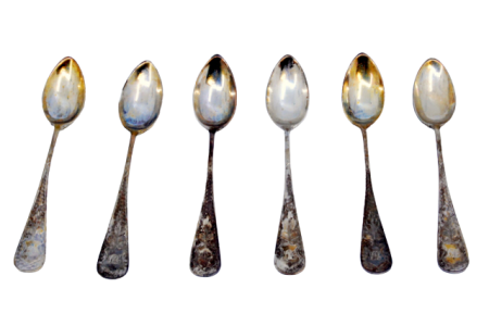 Conjunto de seis colheres de café em prata com relevos nos cabos em tons de dourado.